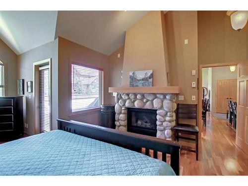 406-701 Benchlands Trail, Canmore, AB - Indoor Photo Showing Bedroom With Fireplace