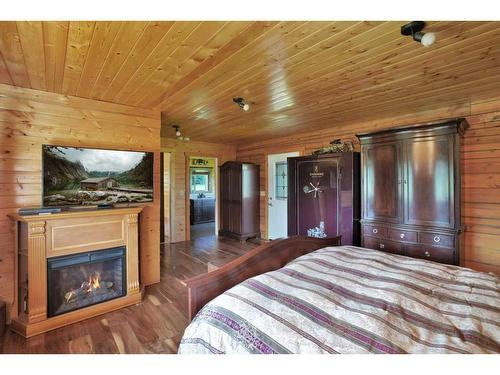 18 West Country Boulevard, Rural Clearwater County, AB - Indoor Photo Showing Bedroom With Fireplace