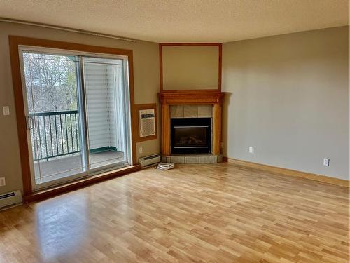 402-5428 51 Avenue, Rocky Mountain House, AB - Indoor Photo Showing Living Room With Fireplace