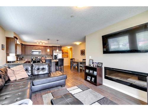 1111-450 Sage Valley Drive Nw, Calgary, AB - Indoor Photo Showing Living Room With Fireplace