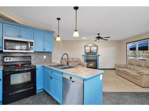 27 Lodge Place, Sylvan Lake, AB - Indoor Photo Showing Kitchen With Fireplace With Double Sink