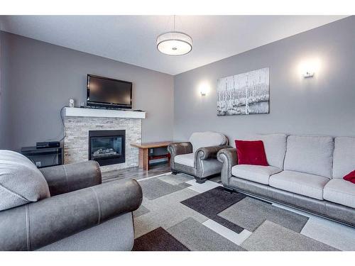 91 Cedar Square, Blackfalds, AB - Indoor Photo Showing Living Room With Fireplace