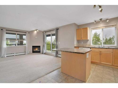 404-5601 Kerry Wood Drive, Red Deer, AB - Indoor Photo Showing Kitchen With Fireplace