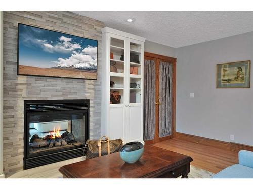 15 Rustic Crescent, Norglenwold, AB - Indoor Photo Showing Living Room With Fireplace