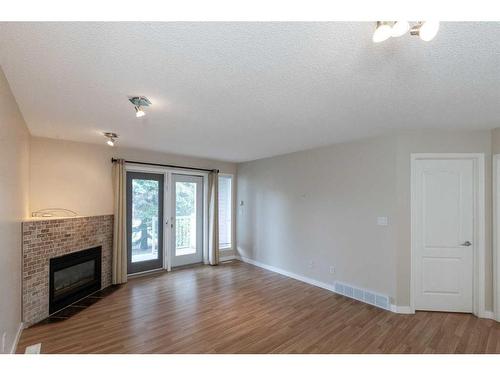 606-5220 50A Avenue, Sylvan Lake, AB - Indoor Photo Showing Other Room With Fireplace