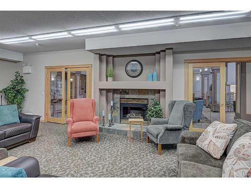 209-4512 52 Avenue, Red Deer, AB - Indoor Photo Showing Living Room With Fireplace