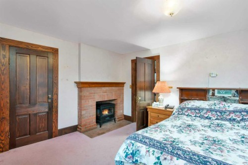 32328 Range Road 42, Rural Mountain View County, AB - Indoor Photo Showing Bedroom With Fireplace
