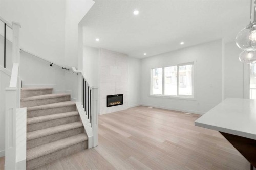 87 Heritage Manor, Cochrane, AB - Indoor Photo Showing Other Room With Fireplace