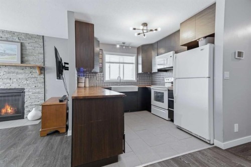 69 Willow Springs Crescent, Sylvan Lake, AB - Indoor Photo Showing Kitchen With Fireplace