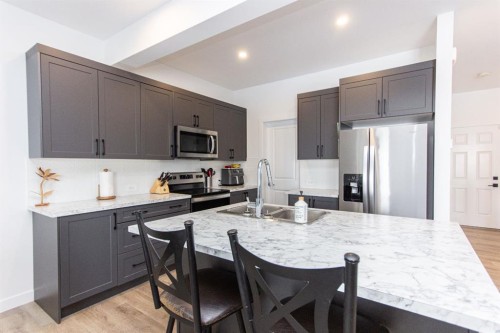 66 Henderson Crescent, Penhold, AB - Indoor Photo Showing Kitchen With Stainless Steel Kitchen With Double Sink With Upgraded Kitchen