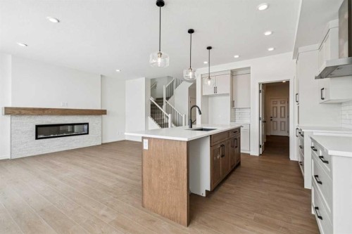 208 Southborough Common, Cochrane, AB - Indoor Photo Showing Kitchen With Fireplace With Upgraded Kitchen