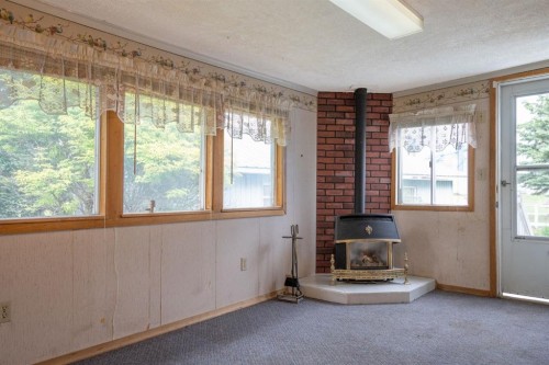 #8 48A Street Close, Alix, AB - Indoor With Fireplace