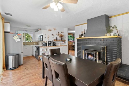 5224 50 Avenue, Sylvan Lake, AB - Indoor Photo Showing Dining Room With Fireplace