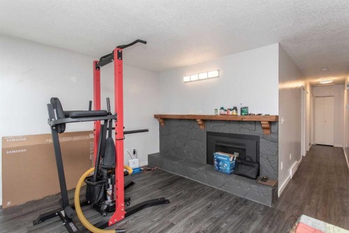 12 Valley Crescent, Lacombe, AB - Indoor Photo Showing Gym Room With Fireplace