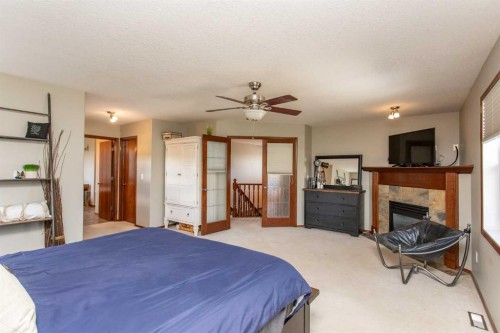 715 700 Ramage Close, Red Deer, AB - Indoor Photo Showing Bedroom With Fireplace