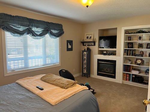 422 West Creek Drive, Cardston, AB - Indoor Photo Showing Bedroom With Fireplace