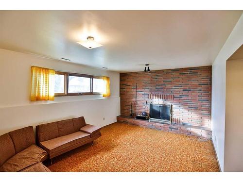 81 N 200 E, Raymond, AB - Indoor Photo Showing Living Room With Fireplace