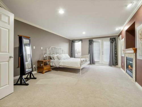 145 Canyon Close West, Lethbridge, AB - Indoor Photo Showing Bedroom With Fireplace