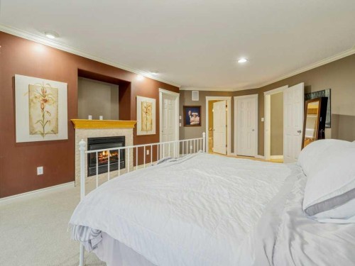 145 Canyon Close West, Lethbridge, AB - Indoor Photo Showing Bedroom With Fireplace