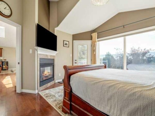 314 Coulee Springs Terrace, Lethbridge, AB - Indoor Photo Showing Bedroom With Fireplace