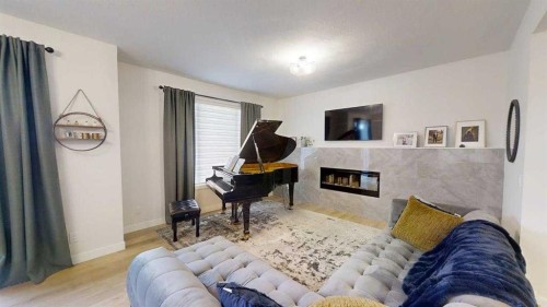 28 Aster Link, Okotoks, AB - Indoor Photo Showing Bedroom With Fireplace