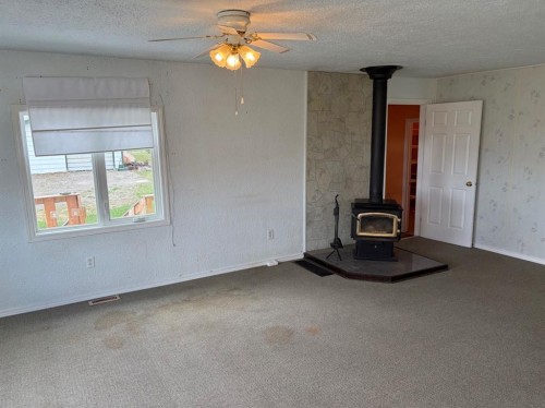 24E 3 Avenue South, Hill Spring, AB - Indoor Photo Showing Other Room With Fireplace