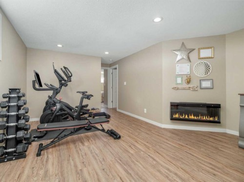553 Mary Cameron Crescent North, Lethbridge, AB - Indoor Photo Showing Gym Room With Fireplace