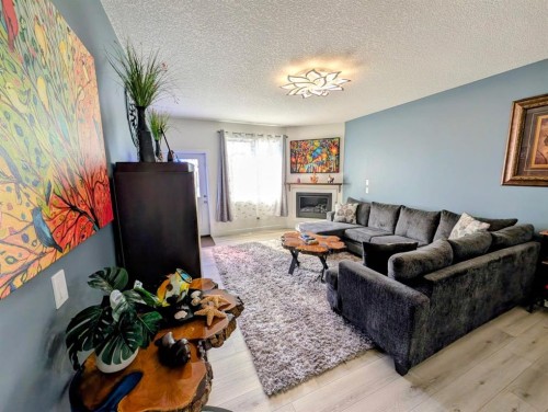 83 Harvest Square, Claresholm, AB - Indoor Photo Showing Living Room With Fireplace