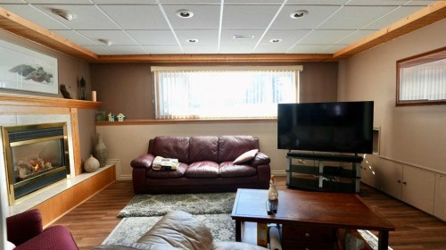 8101 95 Street, Peace River, AB - Indoor Photo Showing Living Room With Fireplace