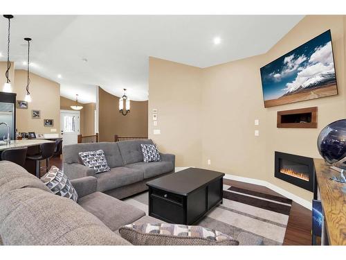 27 Links Place Sw, Desert Blume, AB - Indoor Photo Showing Living Room With Fireplace