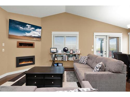 27 Links Place Sw, Desert Blume, AB - Indoor Photo Showing Living Room With Fireplace