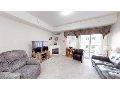 207-2800 13 Avenue Se, Medicine Hat, AB - Indoor Photo Showing Living Room With Fireplace