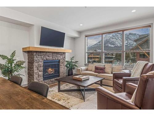 302-1105 Spring Creek Drive, Canmore, AB - Indoor Photo Showing Living Room With Fireplace