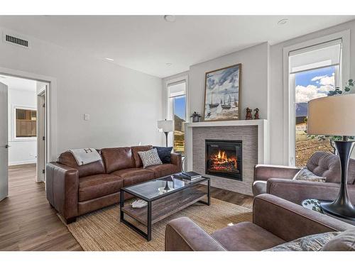 204I-209 Stewart Creek Rise, Canmore, AB - Indoor Photo Showing Living Room With Fireplace