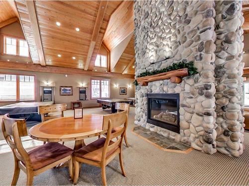 306-170 Crossbow Place, Canmore, AB - Indoor Photo Showing Dining Room With Fireplace