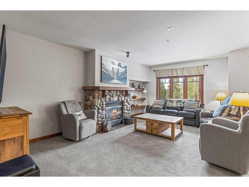 306-170 Crossbow Place, Canmore, AB - Indoor Photo Showing Living Room With Fireplace