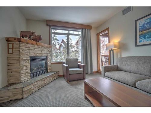 213-190 Kananaskis Way, Canmore, AB - Indoor Photo Showing Living Room With Fireplace