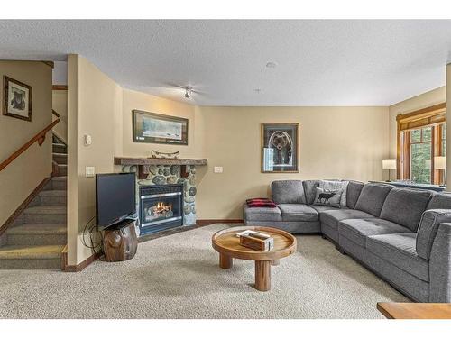 311-150 Crossbow Place, Canmore, AB - Indoor Photo Showing Living Room With Fireplace