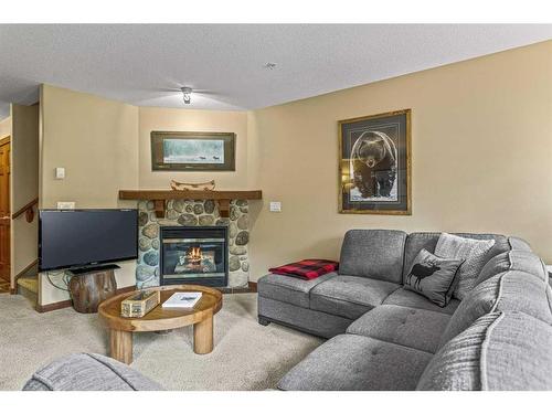 311-150 Crossbow Place, Canmore, AB - Indoor Photo Showing Living Room With Fireplace