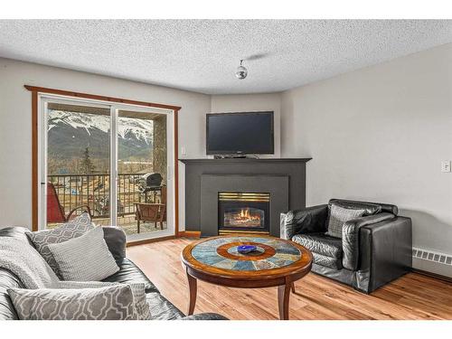 217-115 Elk Run Boulevard Se, Canmore, AB - Indoor Photo Showing Living Room With Fireplace