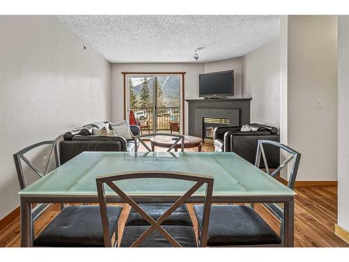 217-115 Elk Run Boulevard Se, Canmore, AB - Indoor Photo Showing Dining Room With Fireplace