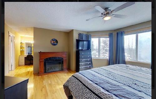 29 594028 Range Road 125, Rural Woodlands County, AB - Indoor Photo Showing Bedroom With Fireplace