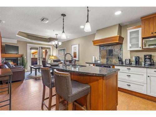 305-191 Kananaskis Way, Canmore, AB - Indoor Photo Showing Kitchen With Fireplace