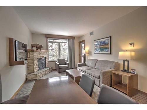 213-190 Kananaskis Way, Canmore, AB - Indoor Photo Showing Living Room With Fireplace