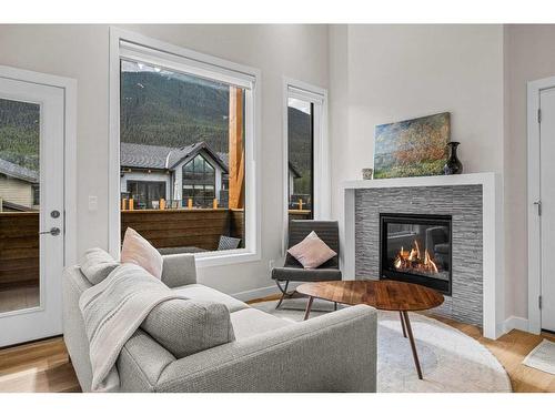 302H-209 Stewart Creek Rise, Canmore, AB - Indoor Photo Showing Living Room With Fireplace