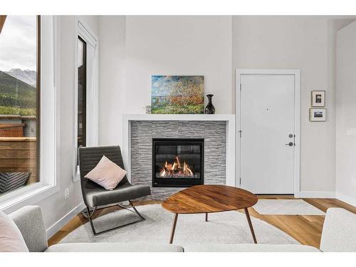 302H-209 Stewart Creek Rise, Canmore, AB - Indoor Photo Showing Living Room With Fireplace