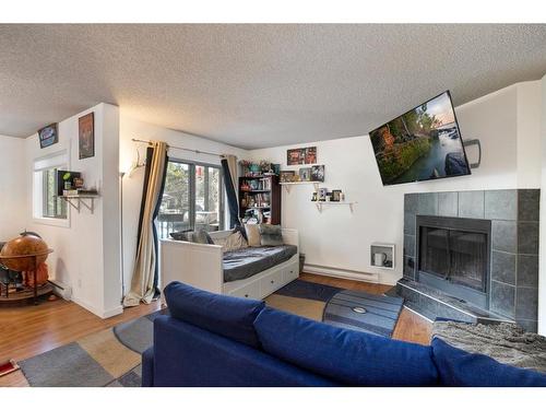 103-440 Cougar Street, Banff, AB - Indoor Photo Showing Living Room With Fireplace