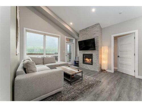 304-106 Stewart Creek Rise, Canmore, AB - Indoor Photo Showing Living Room With Fireplace