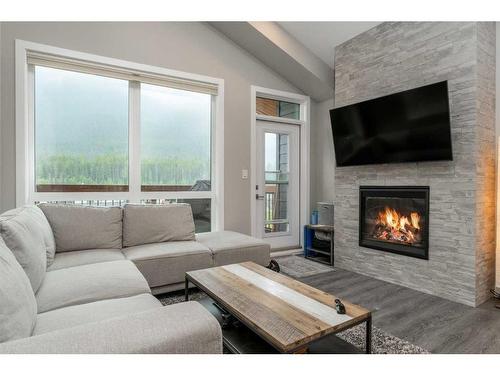 304-106 Stewart Creek Rise, Canmore, AB - Indoor Photo Showing Living Room With Fireplace