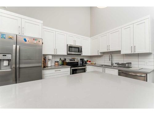 304-106 Stewart Creek Rise, Canmore, AB - Indoor Photo Showing Kitchen With Stainless Steel Kitchen With Double Sink